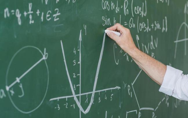 Un profesor escribe en una pizarra.