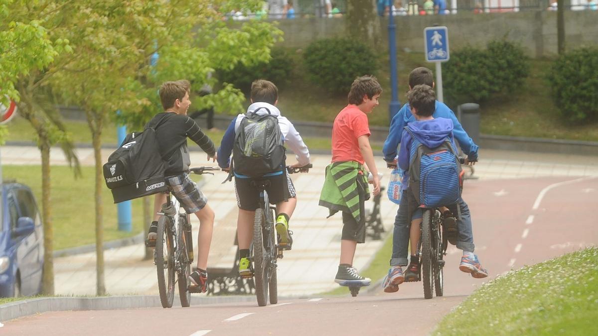 Jóvenes circulando por el bidegorri de Zarautz en bicicleta y patinete.