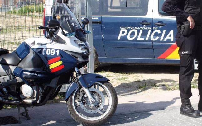 Un agente y dos vehículos de la Policía Nacional. Un agente y dos vehículos de la Policía Nacional.