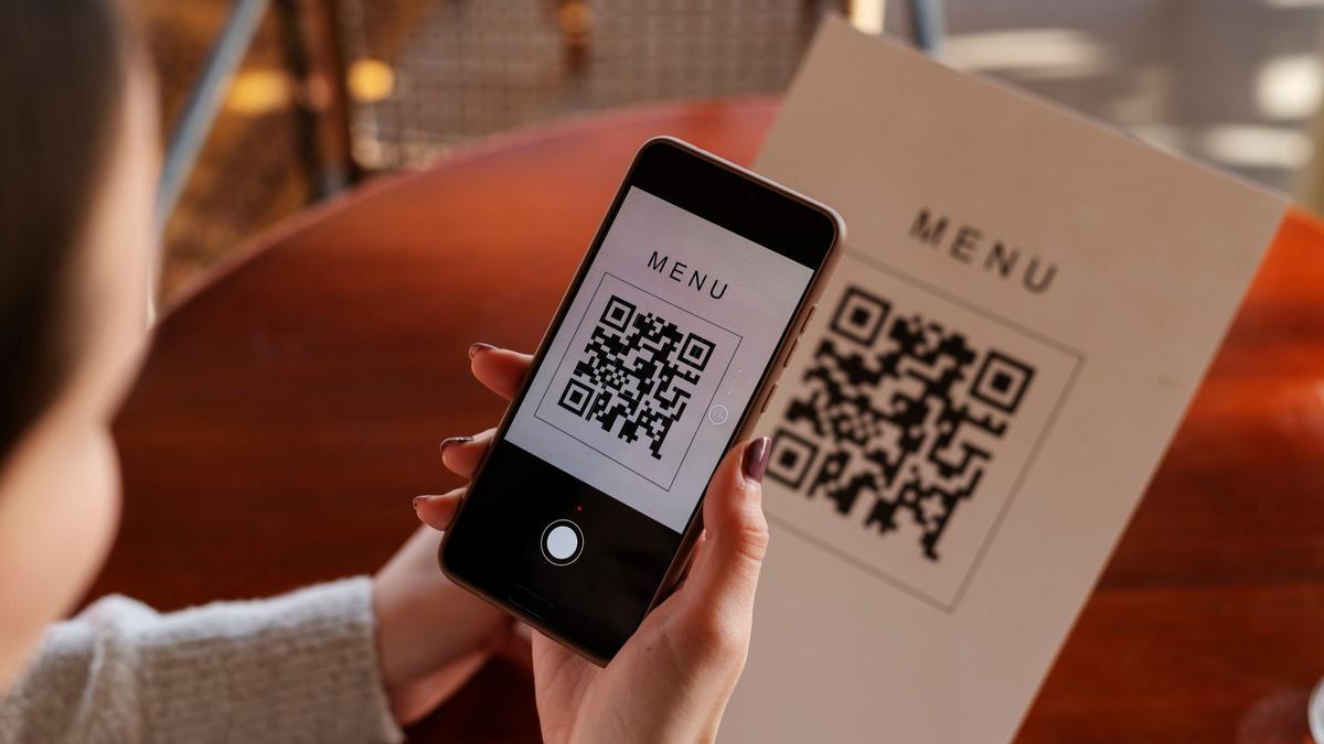 Una persona escanea un código QR en un restaurante.