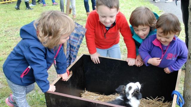 Niños disfrutando con un cachorro de perro pastor en el Artzain Eguna de Amurrio