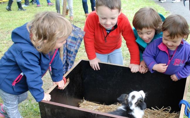 Niños disfrutando con un cachorro de perro pastor en el Artzain Eguna de Amurrio