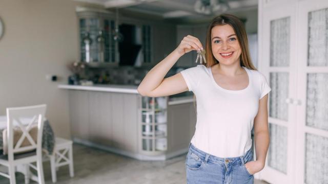 Una joven muestra las llaves de su nuevo piso.