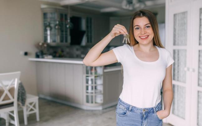 Una joven muestra las llaves de su nuevo piso.