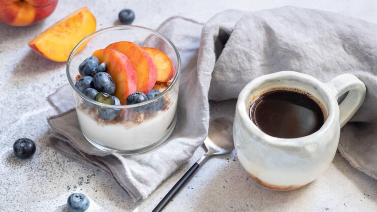 Postre saludable de fruta yogur natural con frutas y una taza de café