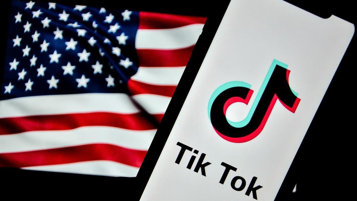 Un teléfono móvil situado ante la bandera de Estados Unidos muestra el logo de TikTok.