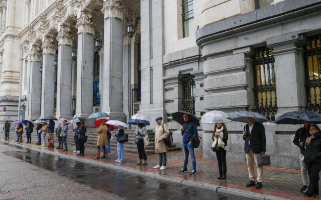 Varias personas se protegen de la lluvia con paraguas frente al Palacio de Cibeles. Varias personas se protegen de la lluvia con paraguas frente al Palacio de Cibeles.