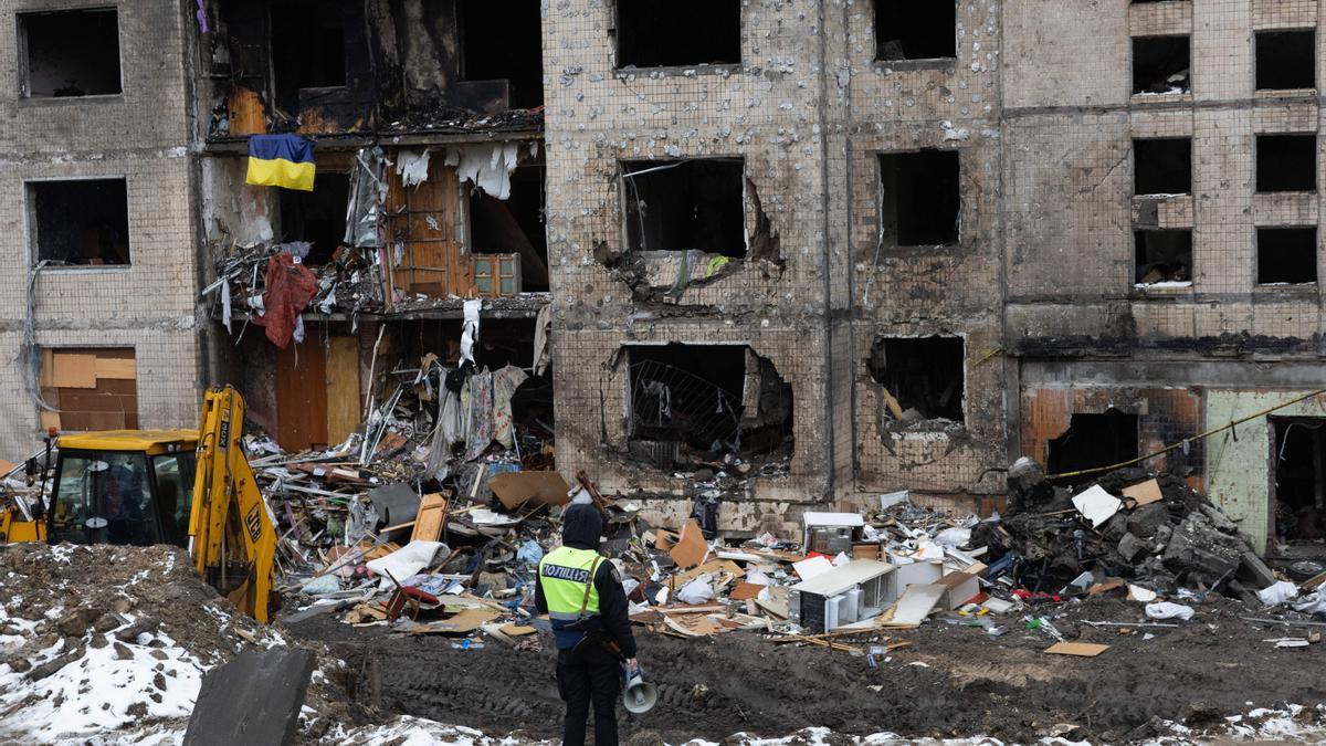 Un policía observa un edificio bombardeado por Rusia.