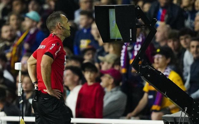 Cuadra Fernández consulta el Var antes de decretar el penalti contra la Real. / EFE