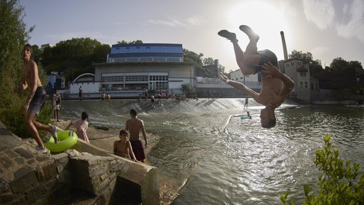 Jóvenes se refrescan en el río Arga durante una ola de calor de este verano. Foto: Unai Beroiz