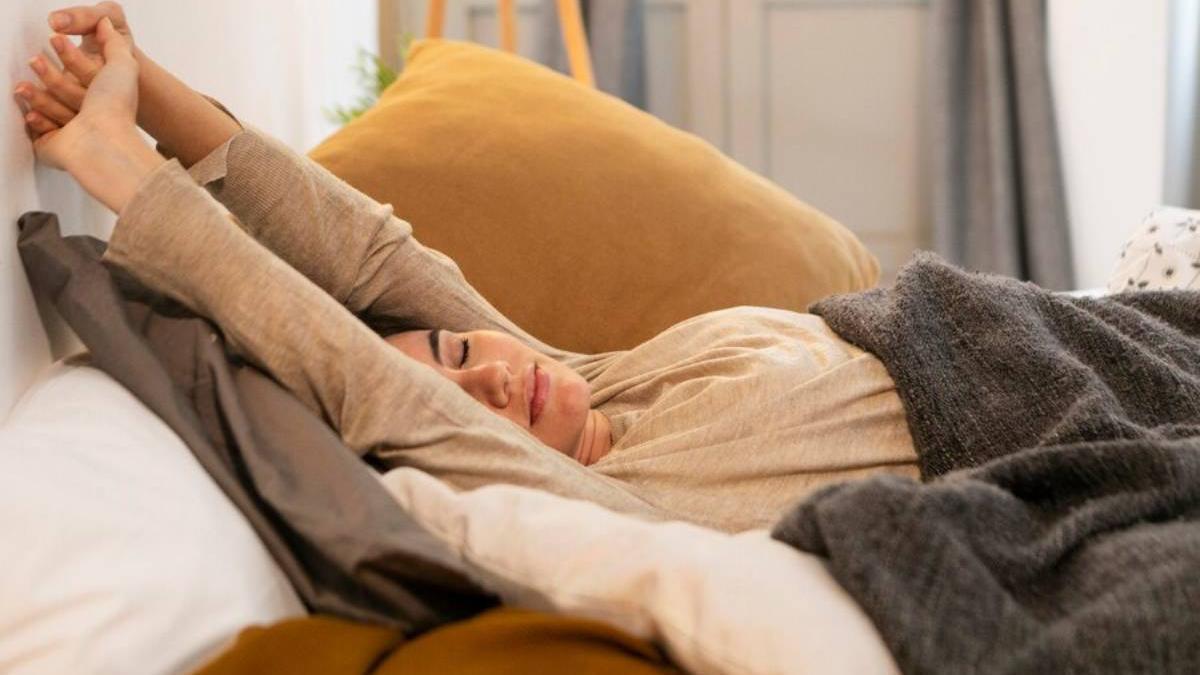 Mujer estirándose por la mañana después de dormir plácidamente