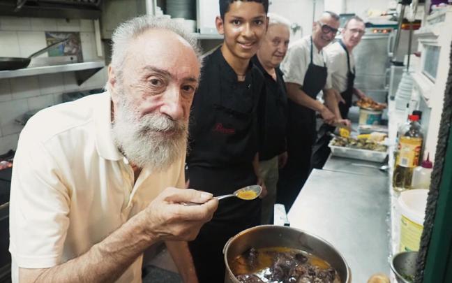 'Mugu' comprueba el punto de sabor y sal de la cazuela bajo la mirada de Roger Hernández en la cocina del Ibai Ondo, su lugar de trabajo durante más de 40 años.