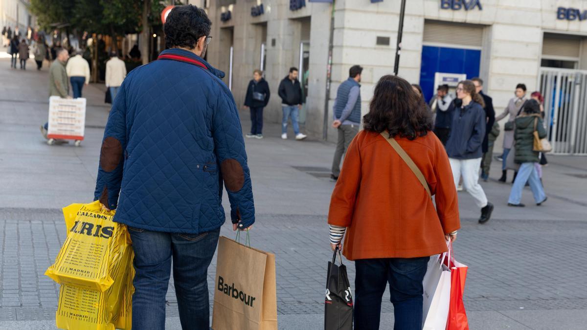 Dos personas llevan varias bolsas de compra