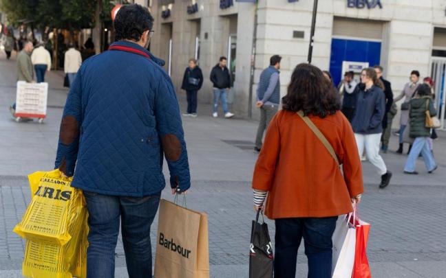 Dos personas llevan varias bolsas de compra