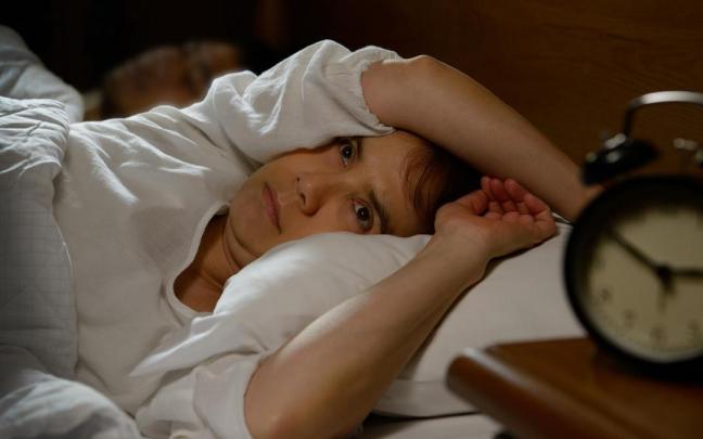 Una mujer despierta por la noche en la cama.