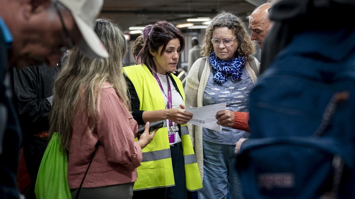 Una trabajadora junto a pasajeros.
