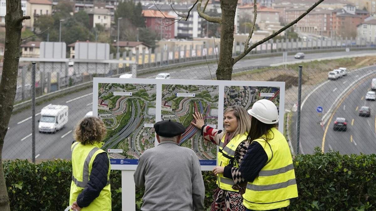 Un hombre atiende las explicaciones de técnicas en el túnel de Polloe, con el enlace en obras al fondo.