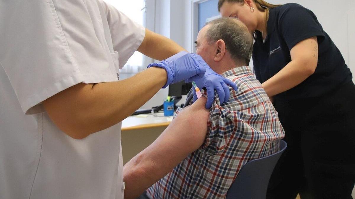 Una enfermera inocula una vacuna a un paciente en el inicio de la campaña de la vacunación contra la gripe estacional y el covid.