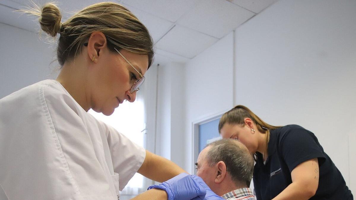 Una enfermera inocula una vacuna a un paciente en el inicio de la campaña de la vacunación contra la gripe estacional y el covid.