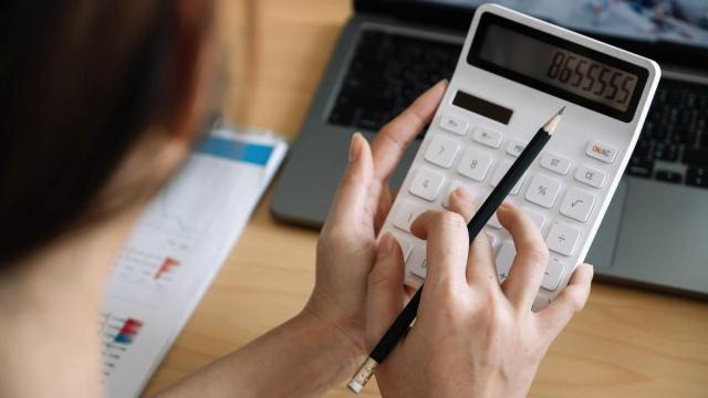 Una mujer hace uso de una calculadora para contabilidad los gastos