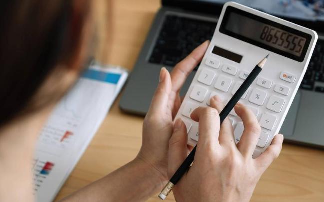 Una mujer hace uso de una calculadora para contabilidad los gastos