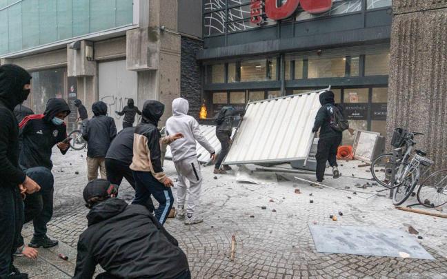 Jóvenes saquean un comercio durante las protestas en Francia.