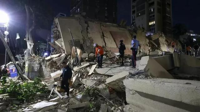 Integrantes de cuerpos de emergencia buscan víctimas este miércoles en una edificación colapsada, en Caracas (Venezuela).
