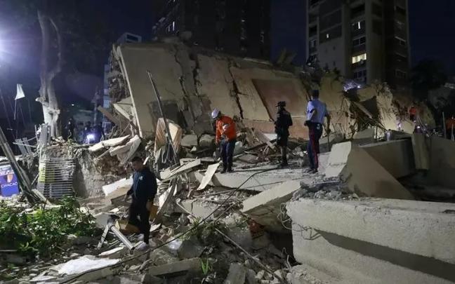Integrantes de cuerpos de emergencia buscan víctimas este miércoles en una edificación colapsada, en Caracas (Venezuela).