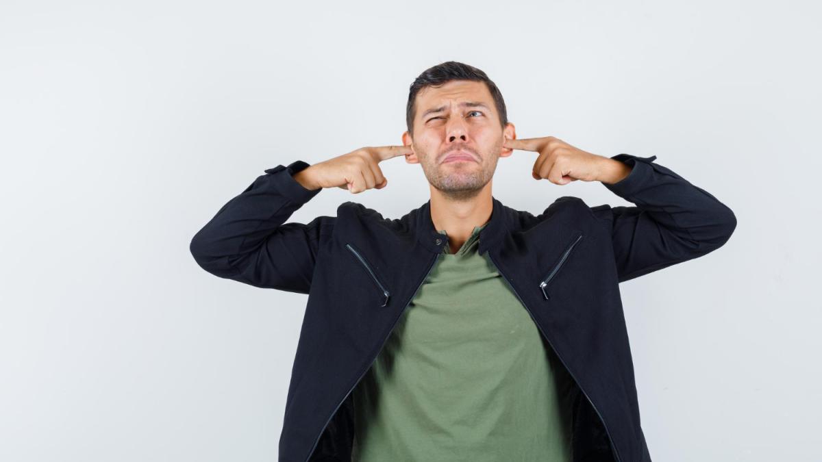 Una persona tapándose los oídos. FREEPIK