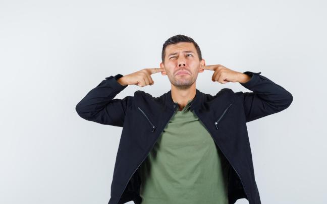 Una persona tapándose los oídos. FREEPIK
