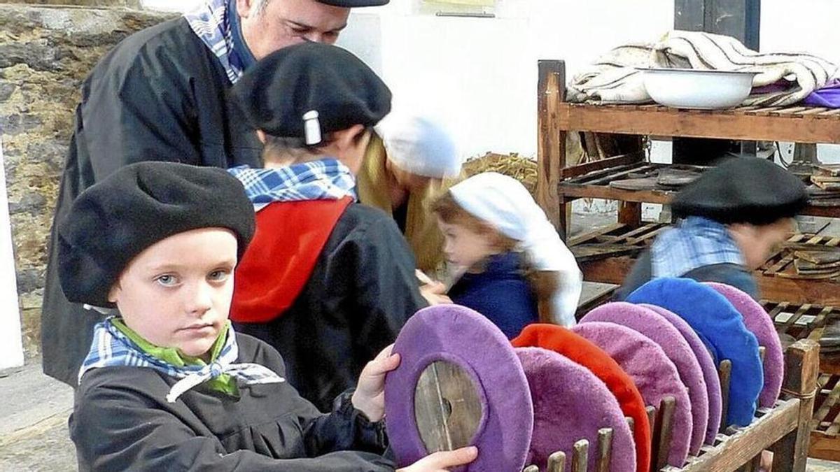 Un niño observa txapelas de diferentes colores