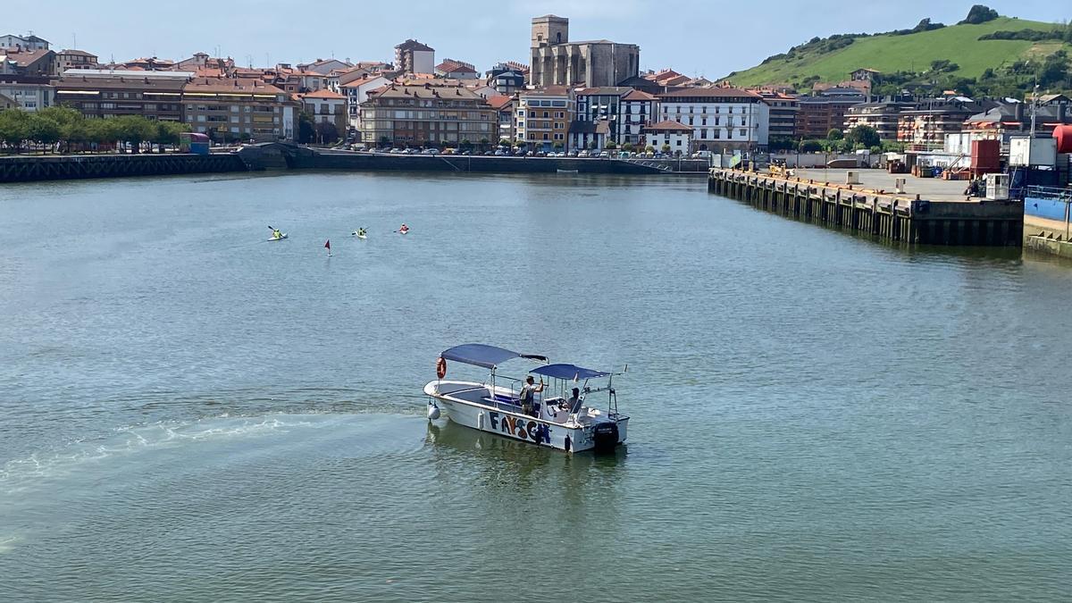 Un barco y piraguas en la ría de Zumaia.