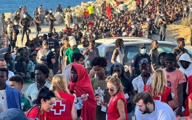 Cruz Roja y Cooperación Sur-Sur reparten alimentos básicos a unos 2.000 migrantes en la Playa del Trampolín (Ceuta).