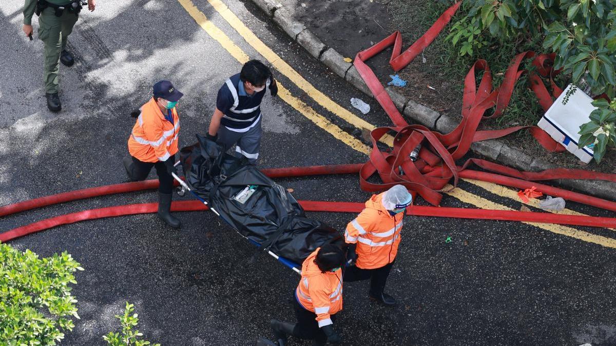 Los servicios de emergencias trasladan uno de los cuerpos hallados en el edificio.
