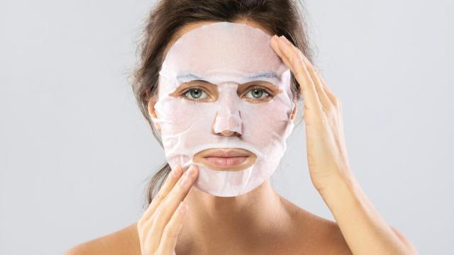 Una mujer se coloca una mascarilla facial.