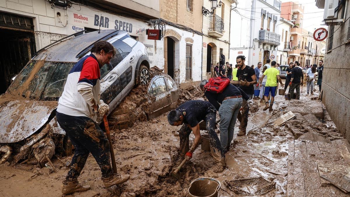 Varias personas limpian los estragos ocasionados por la DANA