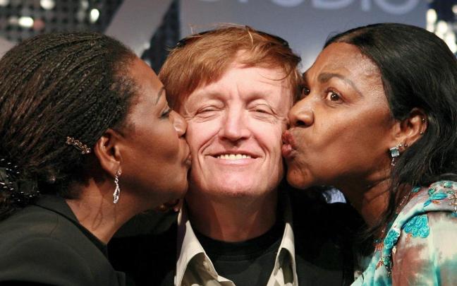 Las cantantes del grupo Boney M, Liz Mitchell (i) y Marcia Barret (d) besan al productor Frank Farian.