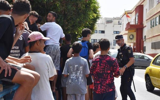 Un grupo de menores espera para ser filiado en una comisaría en Ceuta.