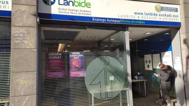 Una mujer frente a una oficina de Lanbide.