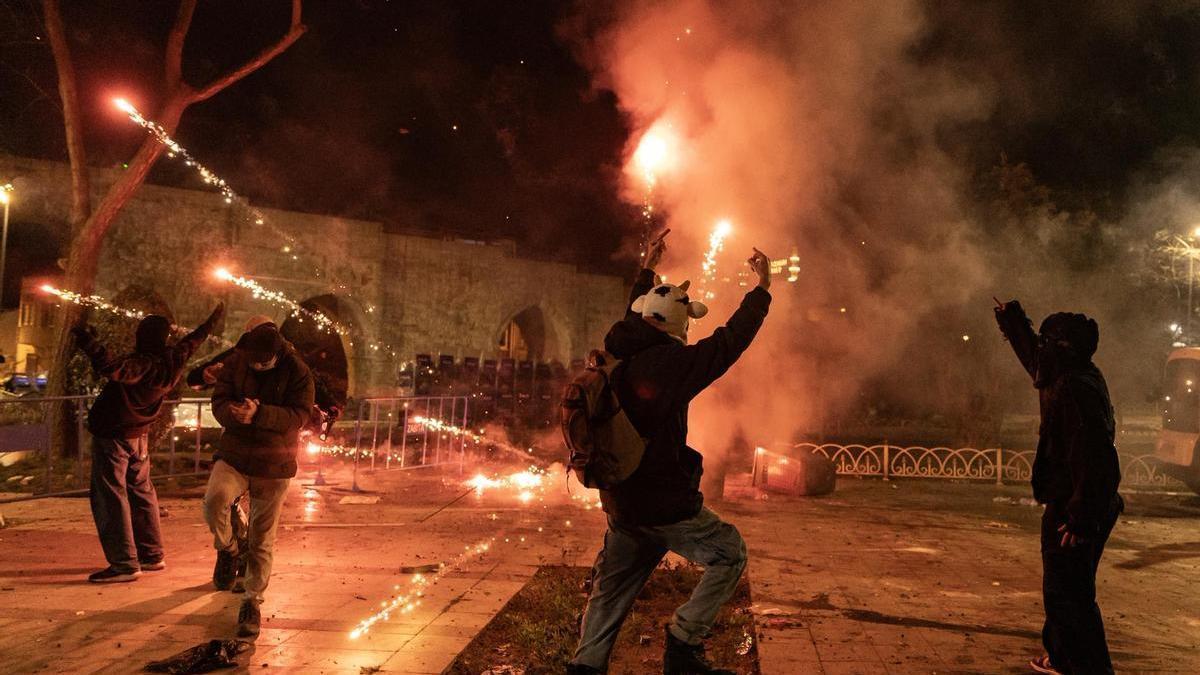 Varios jóvenes protestan contra la detención de Imamoglu lanzando fuegos artificiales ante los agentes en Estambul.