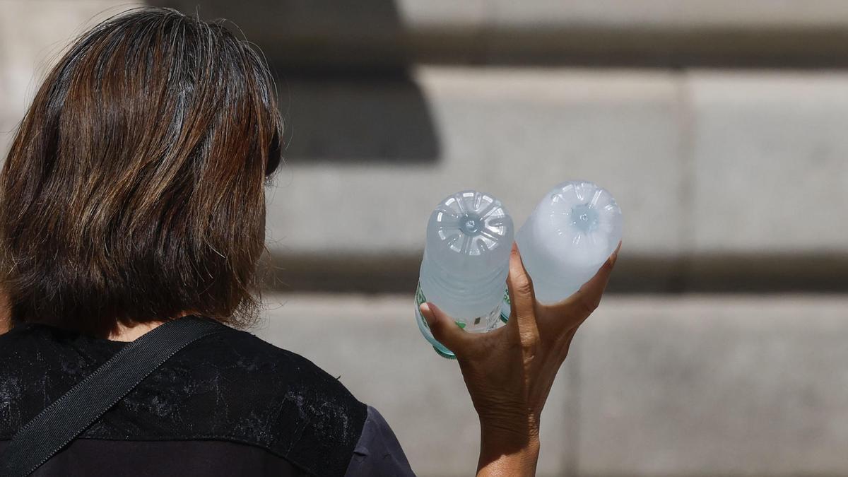 Una mujer vendiendo botellas de agua fría para hacer frente al calor.