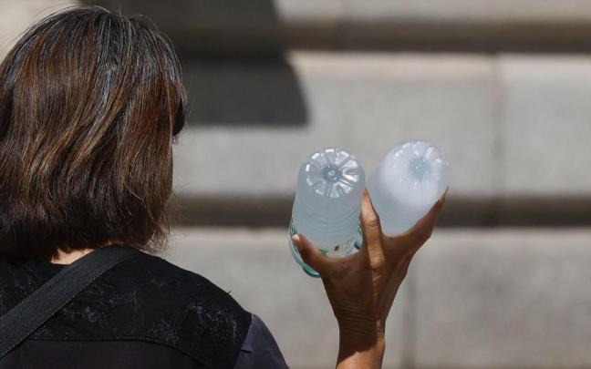 Una mujer vendiendo botellas de agua fría para hacer frente al calor.