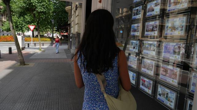 Una joven contempla las ofertas expuestas en una inmobiliaria en Bilbao.