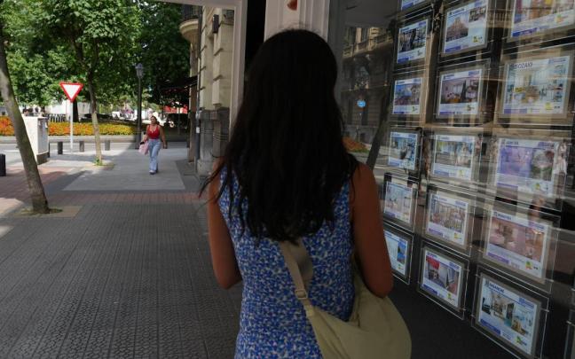 Una joven contempla las ofertas expuestas en una inmobiliaria en Bilbao.