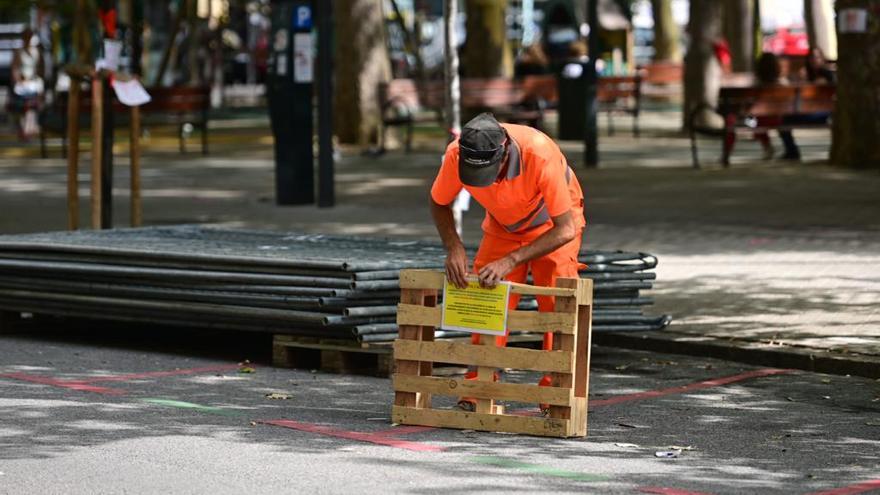 Un operario coloca un cartel en la obras de la plaza de la Cruz.