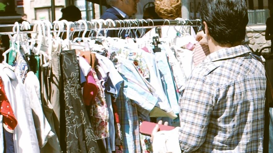 Una mujer mirando prendas en un mercado en Amurrio