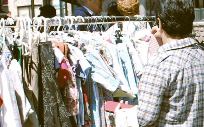 Una mujer mirando prendas en un mercado en Amurrio