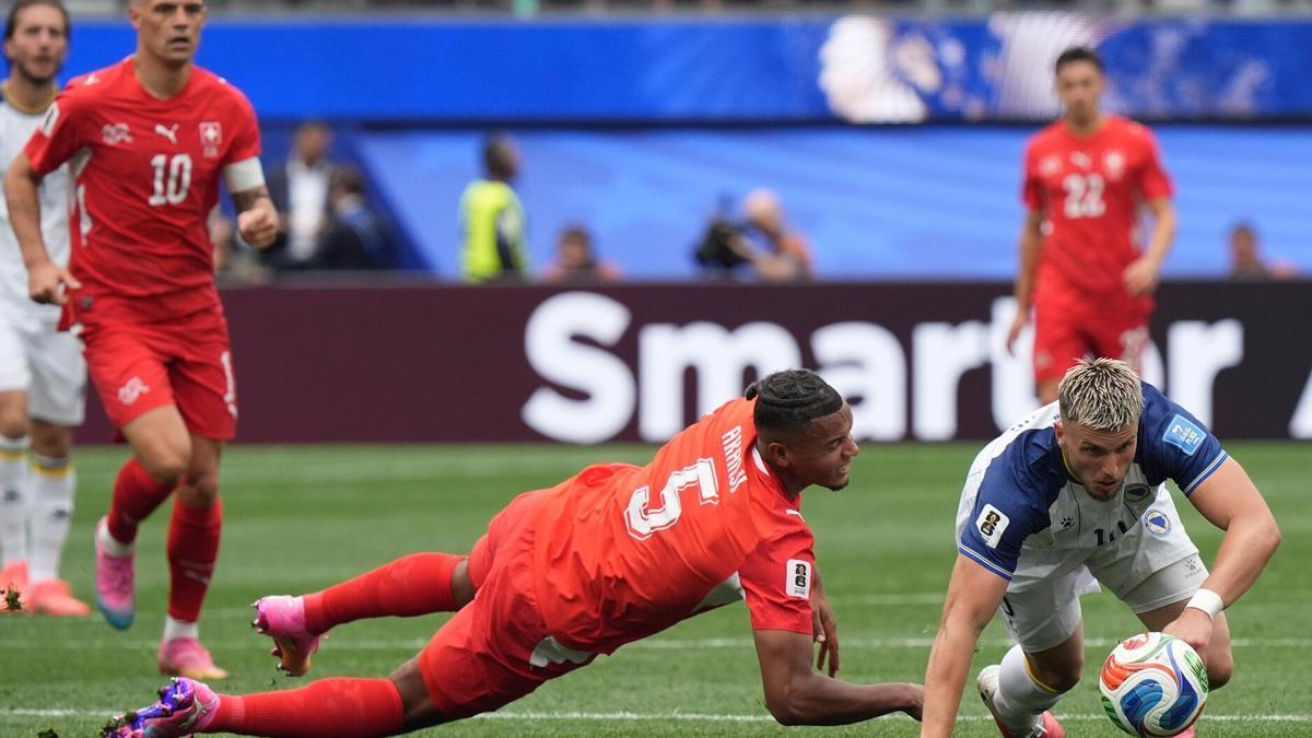 Manuel Akanji (i) de Suiza disputa el balón con Ermedin Demirovic (d) de Bosnia y Herzegovina este jueves, en un partido del grupo B del Mundial.