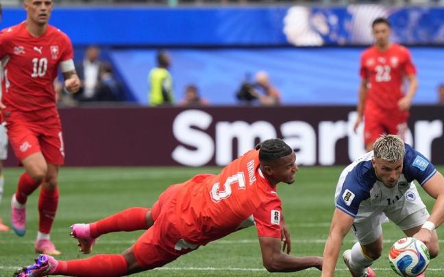 Manuel Akanji (i) de Suiza disputa el balón con Ermedin Demirovic (d) de Bosnia y Herzegovina este jueves, en un partido del grupo B del Mundial.
