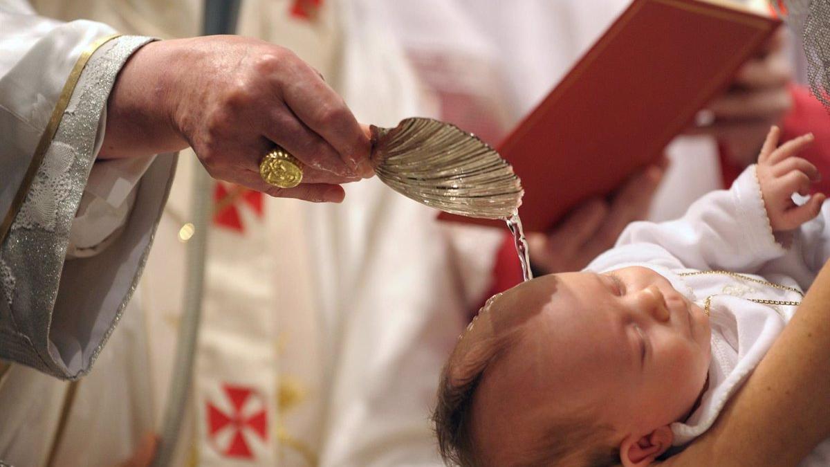 Un sacerdote bautiza a un niño